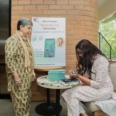 Author Divya G Prasad signing a copy of her debut novel, "Never Give Up," for an appreciative reader. This is a core part of every book launch we host.