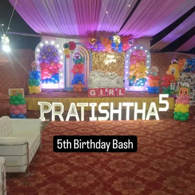 A vibrant and colorful stage for Pratishtha's 5th birthday bash. The double-arched backdrop with balloon columns and large light-up letters fills the space beautifully.