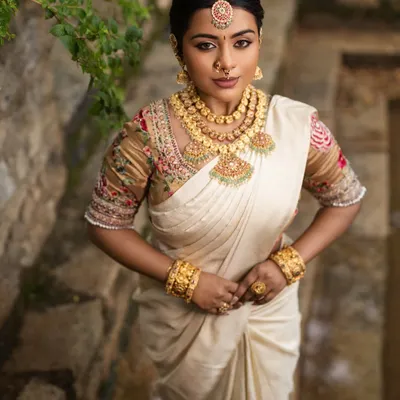 A goddess-like look created for a Varalakshmi festival shoot. The makeup is divine and regal, complementing the traditional white and gold saree.