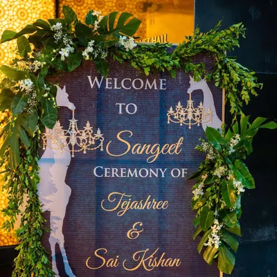 This custom welcome sign introduced the tropical-themed Sangeet, featuring giraffe silhouettes and elegant chandeliers to hint at the unique decor inside. Every detail is designed to build excitement from the moment guests arrive.