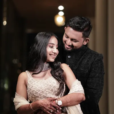A beautiful, intimate moment from a pre-wedding photoshoot. The bride's makeup is soft and natural, with loose waves in her hair, creating a look of effortless romance.