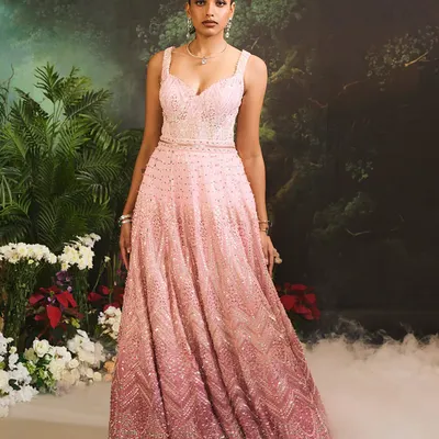 The Celine Gown in a cascade of pink ombre tones. This floor-length gown is adorned with delicate, shimmering embellishments from top to bottom, creating a vision of pure luxury.