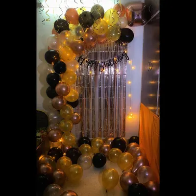 For this birthday surprise, I put together a stylish balloon arch using a mix of black, gold, and chrome balloons. The design is complemented by a shimmery silver curtain and warm fairy lights, creating a perfect backdrop for party photos.