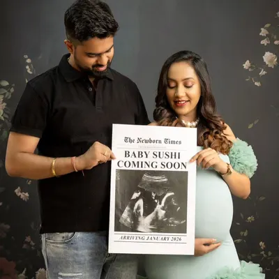 A perfect pregnancy announcement photo. The couple holds up a custom newspaper prop that reads "Baby Sushi Coming Soon," sharing their exciting news in a fun and creative way.