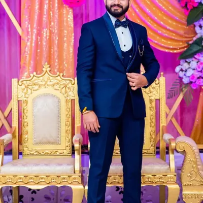 A classic blue tuxedo is always a great choice for a wedding reception. This three-piece set is complete with a satin shawl lapel and a bow tie for a timeless groom's outfit.