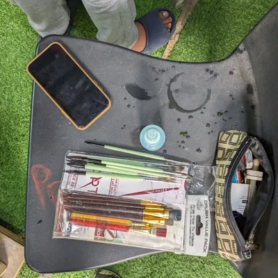 The tools of the trade. A snapshot of a student's desk during our Saturday class, with a fresh pack of brushes, a water pot, and a well-used pencil case ready for action.