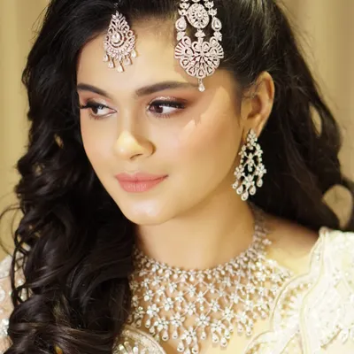 For this celebration, we focused on creating a look of pure grace and poise. The makeup features glowing skin, an ethereal shimmer on the eyes, and a soft lip color, all designed to complement her magnificent diamond jewelry.