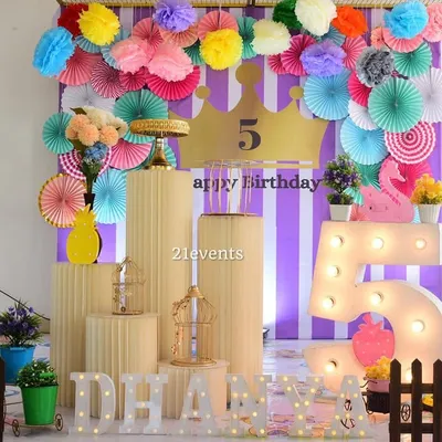 A colorful and budget-friendly setup using paper fans and rosettes. This is a great option for a vibrant, handmade feel.