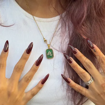 This look is all about confidence. The long, sharp stiletto shape in a deep maroon is both classy and a little dangerous.