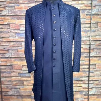 Our navy blue Lakhnavi sherwani is a favorite for grooms and their families. This front view shows the elegant three-piece layering and the shimmering chevron pattern on the jacket.