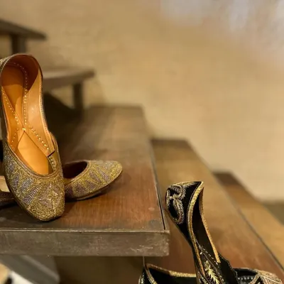 Because every outfit deserves the perfect pair. This image showcases two of my favorite juttis, one in shimmering gold and the other in classic black with gold embroidery.