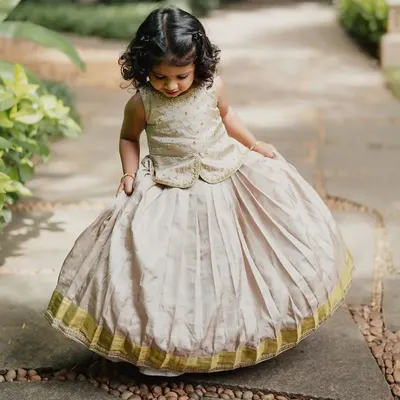 This little one is adorable in a custom pattu pavadai (traditional silk skirt and blouse). I designed this with a pleated skirt and a brocade peplum top for a classic yet comfortable fit.