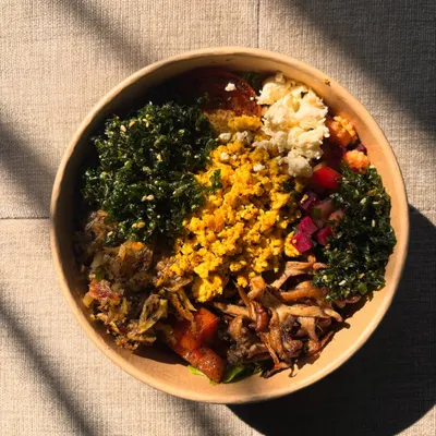 This is our idea of a perfect start to the day. The Breakfast Salad Bowl is a hearty mix of sweet potato roasti, scrambled tofu, crispy spinach, and feta, served with a light French vinaigrette.