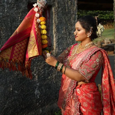 A traditional Gudi Padwa scene, with a model in a beautiful pink and red Nauvari raising the 'Gudi'.