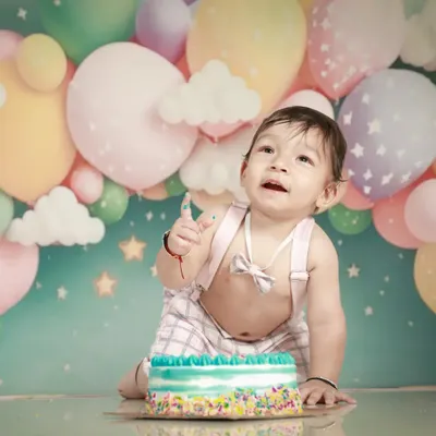The best part of a first birthday is the cake smash! This little one is having the best time with his cake against a dreamy pastel balloon backdrop.