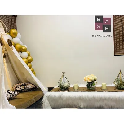 A full view of our chic and cozy boho tent setup, perfect for a surprise birthday or a romantic date night at home. The arrangement includes low seating on a plush rug, elegant table decor, and a beautiful gold and white balloon accent.