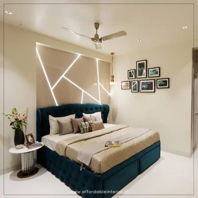 This modern bedroom design features a stunning accent wall with integrated geometric LED lighting behind a deep teal tufted bed, creating a dramatic and luxurious focal point.