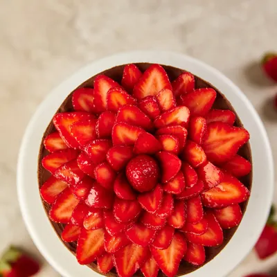 When strawberry season arrives, we celebrate it in style. This beautiful cake is topped with a stunning flower made from fresh, juicy Mahabaleshwar strawberries.