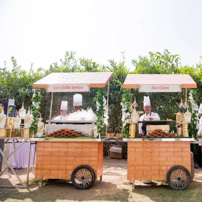 My charming wooden food carts, or 'thelas', set up for an outdoor event. Here you can see the Live Chilla Station and Aloo Chaat station, ready to serve fresh street food favorites.