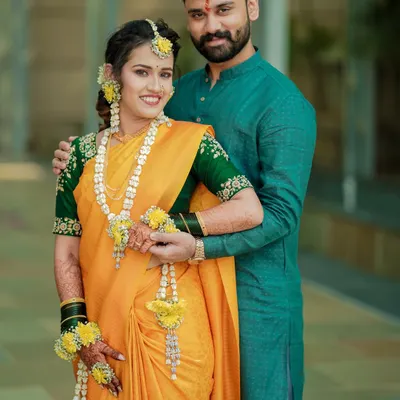 A classic portrait of a Maharashtrian couple during their pre-wedding rituals. The groom's protective embrace and the bride's happy smile tell a beautiful story.