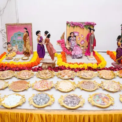The beauty of a baby shower `rukhwat` is truly special. This setup, available for rent, showcases traditional dolls and a wide array of `namkeen` to honor our customs.