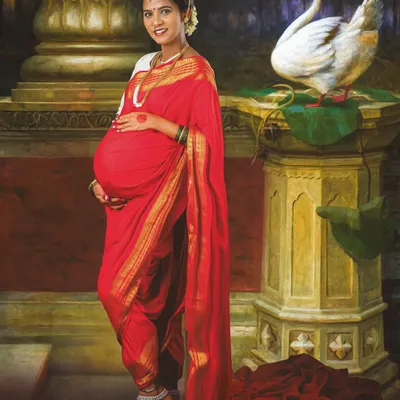 A unique maternity portrait inspired by the classic paintings of Ravi Varma. Dressed in a traditional red saree, this mom-to-be looks like a timeless work of art, complete with rich colors and elegant props.