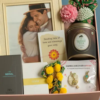 Celebrating the special bond between Bhaiya and Bhabhi with this beautiful Rakhi hamper. It includes a photo frame, matching perfumes, a lumba rakhi set, and masala chai.
