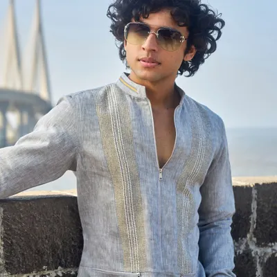A sartorial choice for the discerning gentleman. This grey linen zip-up kurta, pictured against the Mumbai sea link, exemplifies a thoughtful blend of sophistication and comfort.