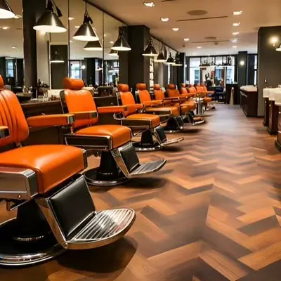 Another perspective of the upscale barbershop, highlighting the herringbone wood flooring and the organized layout of the workstations and washing area. The design ensures efficient workflow for staff while providing a comfortable experience for clients.