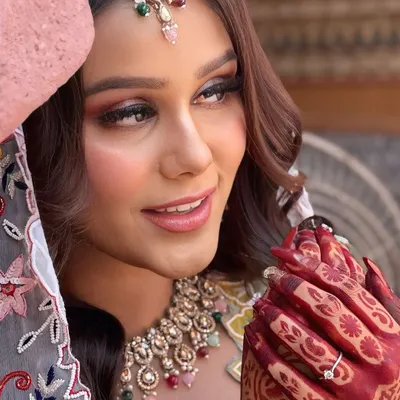 A candid, happy moment from a Mehendi shoot. Her makeup features a beautiful smokey eye with a hint of color.