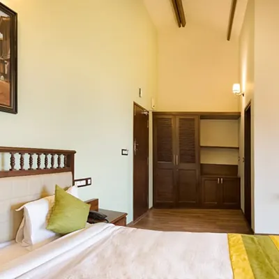 A look inside one of our serene guest rooms, featuring a comfortable bed and natural wood furniture. This is your space to relax, unwind, and rejuvenate your mind, body, and soul.