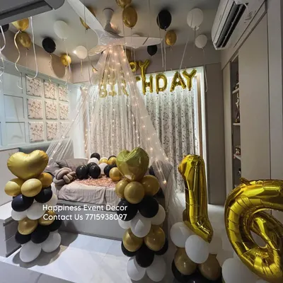 A cozy and romantic net tent decoration for a birthday surprise at home. The setup includes fairy lights, balloons, and foil letters to create a magical canopy.