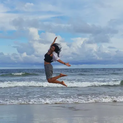 A moment of pure joy, jumping on the beach. This candid lifestyle shot captures my energetic and free-spirited personality, perfect for travel and wellness brands.