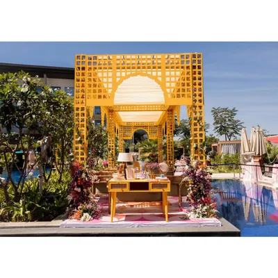 A stunning poolside Mehendi setup featuring a bright yellow trellis structure. This vibrant and sunny design is perfect for a sundowner event, creating a cheerful atmosphere for guests.