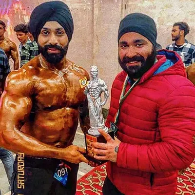 A proud moment receiving the silver medal at a Mr. India competition. This trophy represents countless hours of disciplined training and diet, proving that hard work pays off.