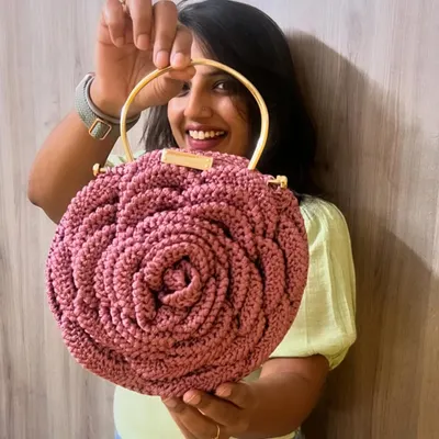 Here I am with one of my favorite dusty pink Rose Bags. The intricate petal design is created with soft cotton yarn, and the golden ring handles add a touch of elegance.
