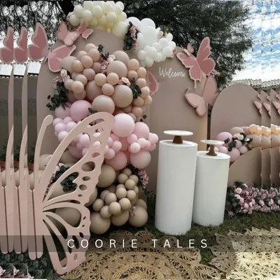 Your celebration can be as delicate and beautiful as a butterfly's wing. This outdoor setup features intricate, large-scale butterfly cutouts, a soft pink and neutral balloon arrangement, and floral accents for a truly enchanting experience.