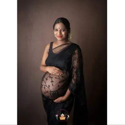 A beautiful smile from this glowing second-time mom. This portrait showcases how the sheer black lace saree can be styled to create a look that is both traditional and modern.