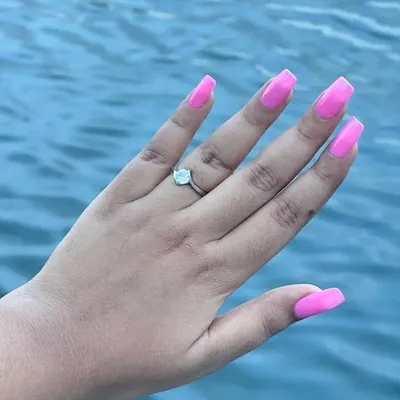 A vibrant, eye-catching neon pink gel polish on long, square-shaped extensions. This color is perfect for vacations, parties, or anytime you want your nails to be the center of attention.