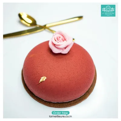 A close up of one of our signature desserts. This piece, with its smooth velvet finish, edible gold flake, and delicate sugar rose, exemplifies the French pastry techniques we bring to all our baked goods.