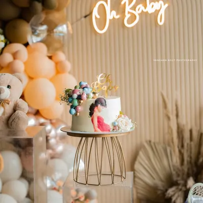 A beautifully styled baby shower cake and decor setup, featuring a boho theme with balloons and a neon 'Oh Baby' sign. I capture the aesthetic of your event to complete the story.