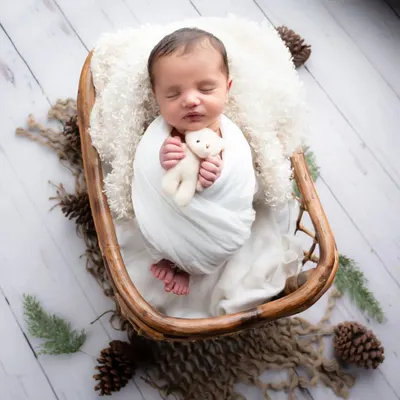 I just can't get enough of this little one. A simple, rustic setup with a cozy wrap and a soft teddy bear allows the baby's natural sweetness to shine through.