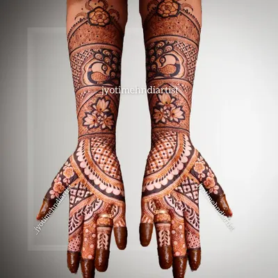 A beautiful full-hand Indian mehndi design, showcasing a blend of traditional patterns, peacock motifs, and floral elements.