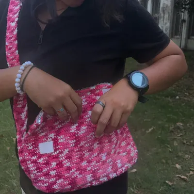 Showing how much the messenger bag can hold. It has a flap closure with a lace detail to keep everything safe inside.