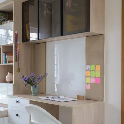 This study area for a young girl includes a whiteboard, pinboard, and ample desk space. The overhead cabinets with smoked glass provide stylish storage for books and supplies.
