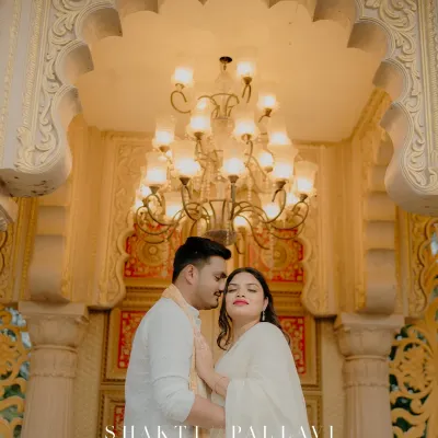 A moment of royal romance under a grand chandelier. The warm light and intricate details of the palace create a luxurious setting for this intimate couple portrait.