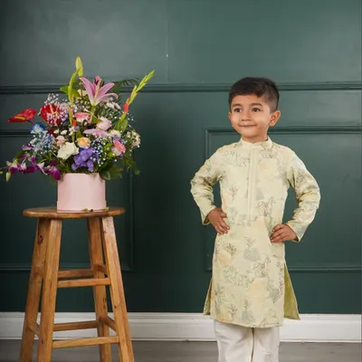 Little man, big style. This little boy looks dapper and ready for any event in a pale green printed kurta set.