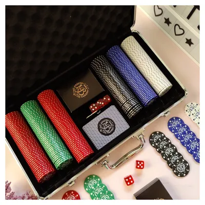 Make your game nights unforgettable with a personalized poker set. This image shows a complete set with custom-branded chips, cards, and dice, all neatly arranged in a professional aluminum carrying case.