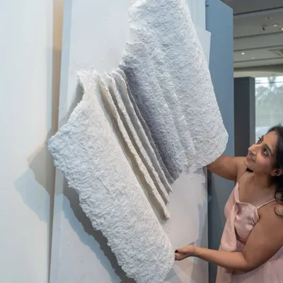 This piece is 'The Flight of Knowledge'. Its open-book form, crafted from upcycled paper, evokes the textures of lived experience, with each fold representing a chapter of learning.