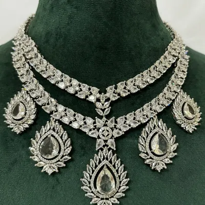 A stunning layered American diamond necklace set for rent. The brilliant-cut stones provide a dazzling look, and the set includes matching drop earrings.